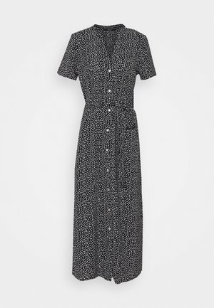 Musta napillinen mekko, jossa on lyhyet hihat, valkoisia pilkkuja, vyötärönauhalla ja pitkä, laskeutuva siluetti. Pehmeä kangaspinta.