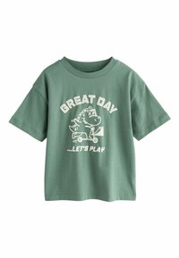 Grünes Baumwoll-T-Shirt mit Rundhalsausschnitt und kurzen Ärmeln, mit weißem Schriftzug "GREAT DAY" und einem Comic-Dinosaurier, der einen Roller fährt.