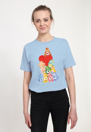 Lys blå bomulds T-shirt med et farverigt grafik af stablede tegneserie-bjørne og et rødt hjerte design i midten.