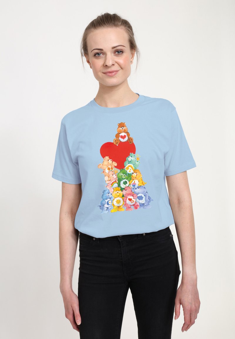 T-shirt di cotone azzurro chiaro con una grafica colorata di orsi cartoon impilati e un cuore rosso al centro.