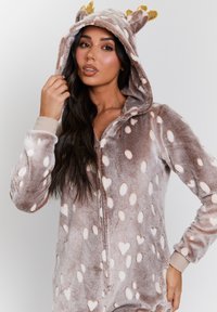 Fleece-Overall mit einer Kapuze und Ohren-Akzenten, einem Reißverschluss vorne und einem gepunkteten Muster in Beige- und Cremetönen. Weiche, plüschige Textur.