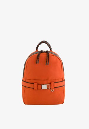 Mochila compacta naranja con asa superior en negro, cremalleras dobles y cinturón delantero con hebilla plateada y anilla metálica.