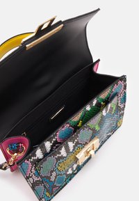Kolorowa torebka z misternymi geometrycznymi wzorami, z czarnym skórzanym zewnętrzem, złotymi akcentami i żółtą podszewką.