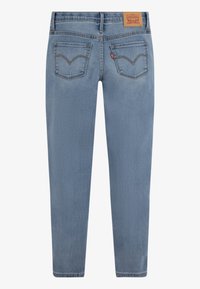 Ljust blå denimjeans med rak passform, med två bakfickor med en sydd design och en brun läderetikett i midjan.