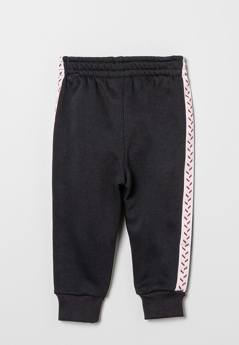 Pantaloni sportivi neri con una vita elastica, caratterizzati da cuciture a zigzag rosse su strisce laterali bianche e polsini aderenti alle caviglie.