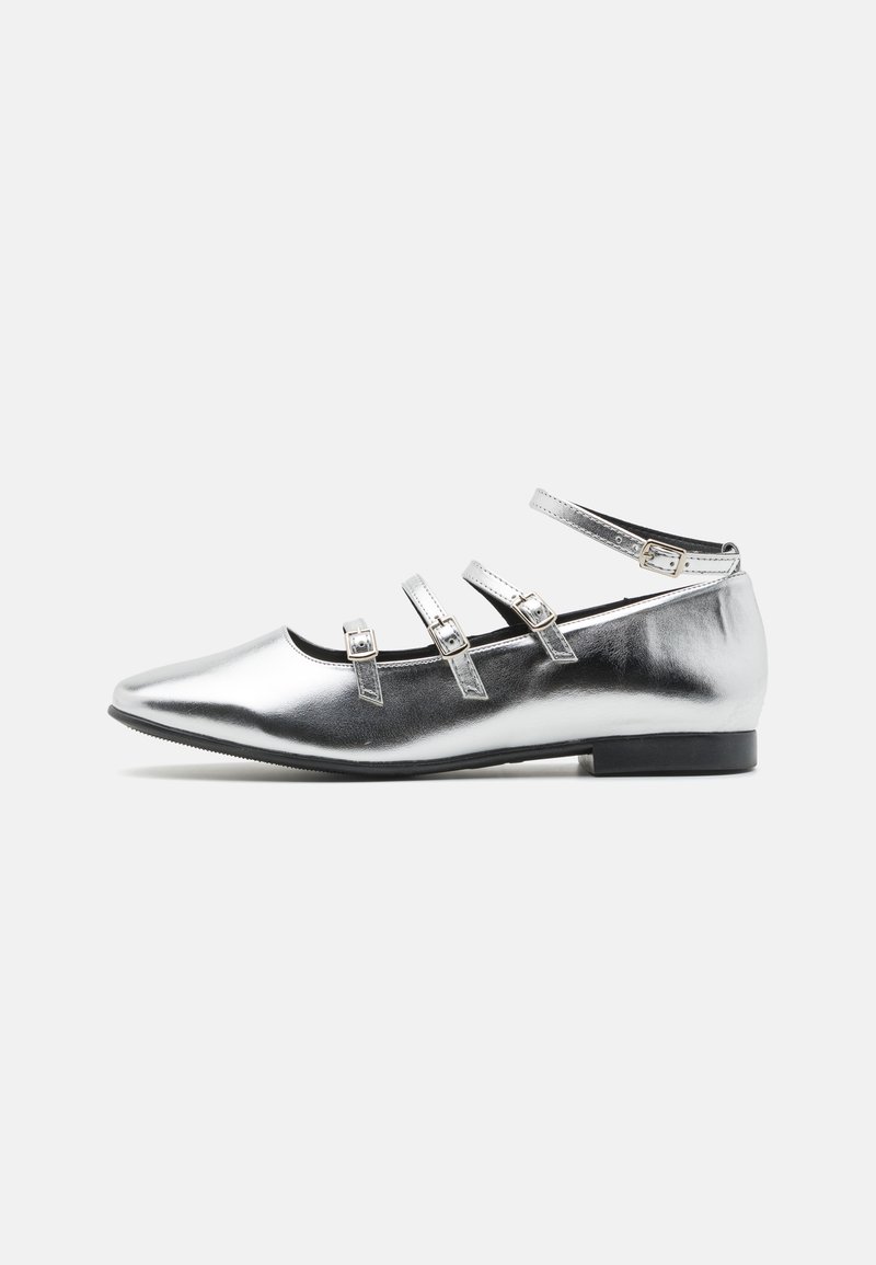 Ballerines métalliques argentées avec un bout pointu, trois brides réglables et un petit talon noir. Texture lisse avec un design minimaliste.
