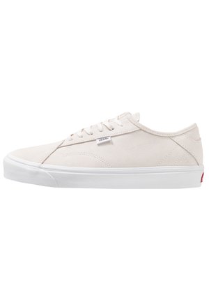 Basket basse blanche Vans avec un design à lacets, dessus en daim et semelle en caoutchouc blanche, montrée de côté sur fond blanc.
