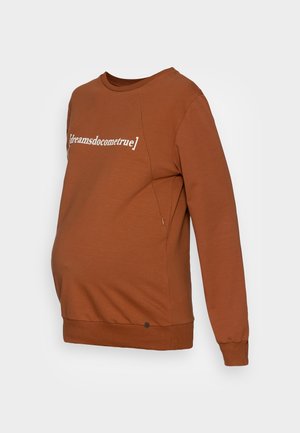 Brązowa bluza ciążowa z długimi rękawami, bocznym zamkiem błyskawicznym i białym napisem „dreamsdocometrue" na klatce piersiowej.