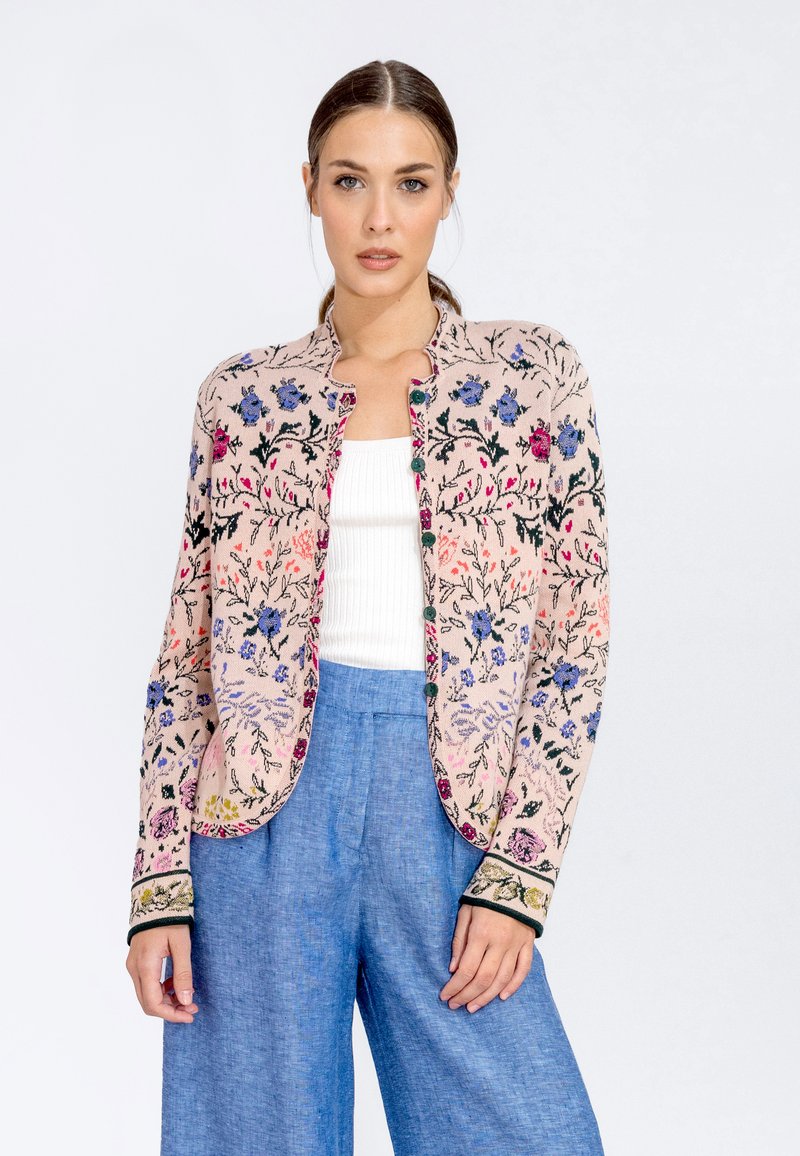 Embroidered jacket in light pink with floral patterns, round neckline, green accents, and seven buttons down the front. Soft texture.