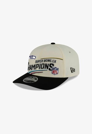 White and black snapback hat with "Super Bowl LX Champions" text, NFL logo, and Seattle Seahawks emblem embroidered on front.