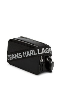 Borsa a tracolla nera rettangolare con due cerniere argento e una tracolla nera che mostra "KARL LAGERFELD JEANS" in testo bianco.