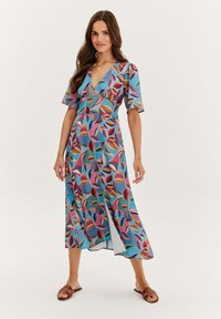 Midi šaty s květinovým vzorem, V-výstřihem, krátkými rukávy a volným střihem. Barvy zahrnují modrou, růžovou, červenou a hnědou. Hladká textura.