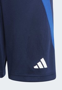 Shorts de sport navy avec un panneau latéral bleu, fabriqués en tissu lisse. Présente un logo blanc avec trois bandes près de l'ourlet.
