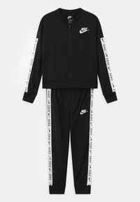 Chándal negro con chaqueta de cremallera y pantalones con cintura elástica. Presenta el logo de Nike en blanco y franjas de marca a lo largo de las mangas y las piernas. Textura suave.