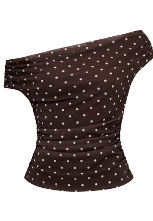 Brun topp med én skulder, hvite polkadotter, rynkede sider og elastisk kort erme på venstre side.