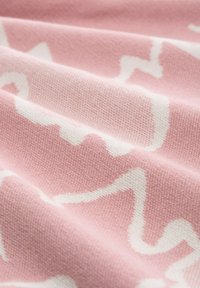 Bavlněná tkanina s růžovým pozadím a bílým vlnitým vzorem, která má jemnou strukturu a hladký splývavý vzhled.