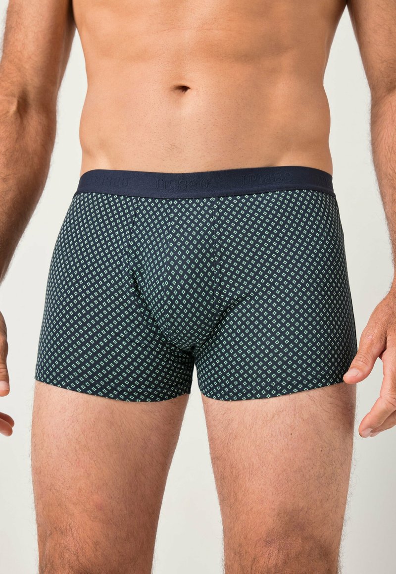 Boxers ajustados en color navy con un patrón geométrico en verde. La cinturilla elástica lleva el logo de la marca. Tejido suave y diseño ajustado.
