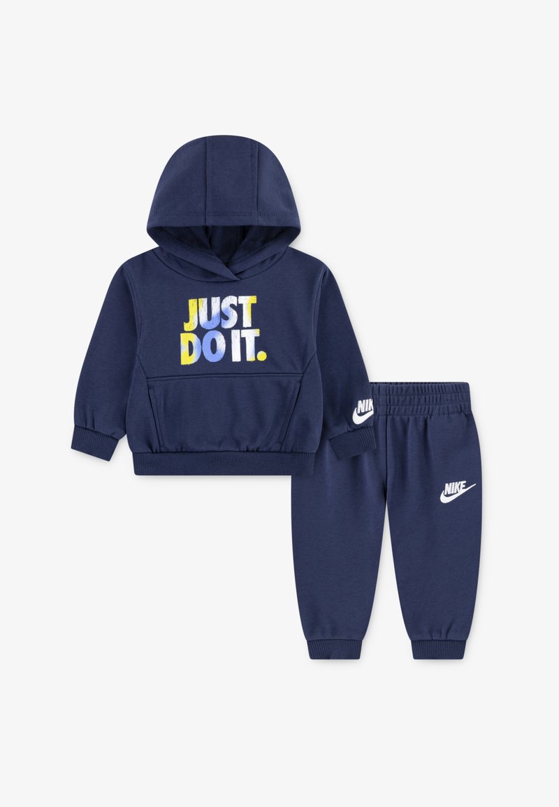 Dunkelblaues Hoodie- und Jogginganzug-Set aus cotton-mix. Das Hoodie zeigt den Aufdruck "JUST DO IT." in Gelb, Blau und Weiß; die Hose hat das Nike-Logo.