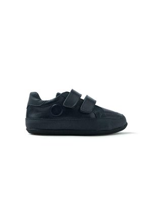 Baskets en cuir noir avec deux bandes velcro, bout rond, panneaux latéraux texturés et un emblème circulaire sur le côté extérieur.