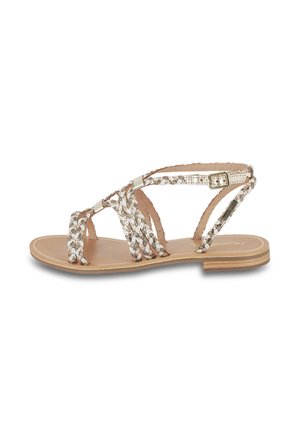 Flad sandal med flettede metalliske og beige remme og en lille spænde lukning på en tan sål og lav lagdelt hæl.