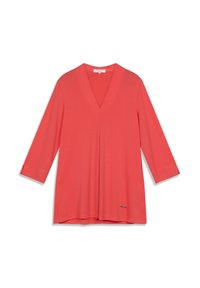 Tunique corail à col en V avec manches trois-quarts, en tissu lisse, arborant un discret logo près de l'ourlet.