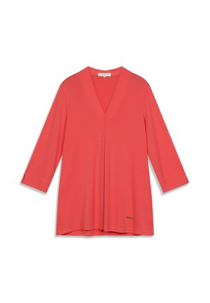 Tunique corail à col en V avec manches trois-quarts, en tissu lisse, arborant un discret logo près de l'ourlet.