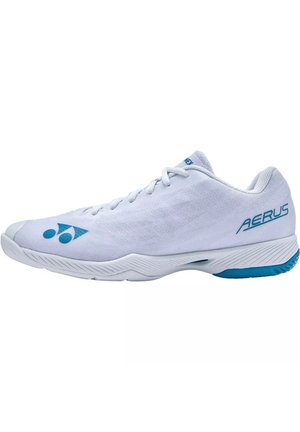 Scarpa sportiva bianca con taglio basso, scritta blu "AERUS" sul tallone e logo Yonex sul lato, progettata per l'uso negli sport indoor.