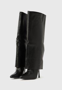 Čierne kožené čižmy na vysokom podpätku s predĺženou šachtou, vyznačujúce sa hladkou, lesklou textúrou a špicatou špičkou.