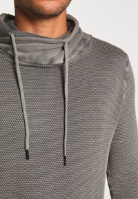 Grauer, strukturierten Hoodie mit einem Schalkragen, der über einfaches Lichtfarbe Zugbänder verfügt und einem atmungsaktiven, gewebten Stoffmuster.