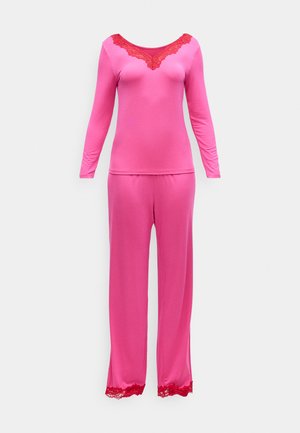 Långärmad pyjamas i rosa med spetstaccent vid halsringningen och spetskant vid byxornas fåll, tillverkad av mjukt, elastiskt tyg.