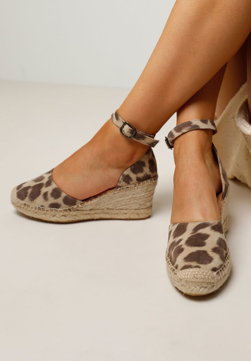 Leopard print espadrille wedges with a canvas upper, ankle strap, and braided jute wedge heel. Soft texture, neutral colors.