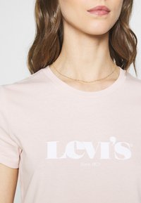 Rosa bomull t-shirt med en vit "Levi's" logotyp, rund halsringning och korta ärmar, med mjuk textur och klassisk passform.