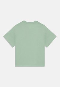 T-shirt vert menthe à manches courtes avec un col rond. Fabriqué en tissu doux. Présente un design simple sans motifs ni ornements.