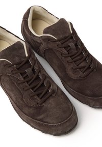Scarpe in suede marroni con punta arrotondata, dotate di lacci marroni scuri e fodera interna color crema, presentano una superficie testurizzata e suola in gomma.