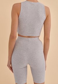 Gray ribbed crop top and matching high-waist shorts feature a fitted design. The fabric has a soft texture and smooth finish.