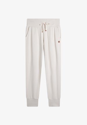 Joggers de color crema con cintura ajustable, bolsillos laterales, tobillos ajustados y un pequeño logo en el muslo. Textura de tela suave.