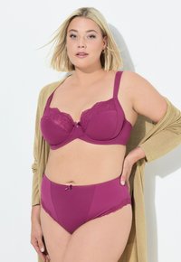 Reggiseno in pizzo viola e rete con una finitura liscia; culotte alte coordinate con accenti in pizzo e un piccolo fiocco decorativo.