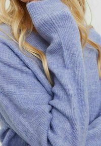 Hellblauer Pullover aus weichem, dickem Strickstoff mit geripptem Muster und langen Ärmeln, ausgestattet mit einem weiten Halsausschnitt und lockerer Passform.