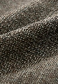 Woven fabric in earthy brown tones with a textured, fuzzy surface. Features a grid-like pattern and a soft, durable feel.