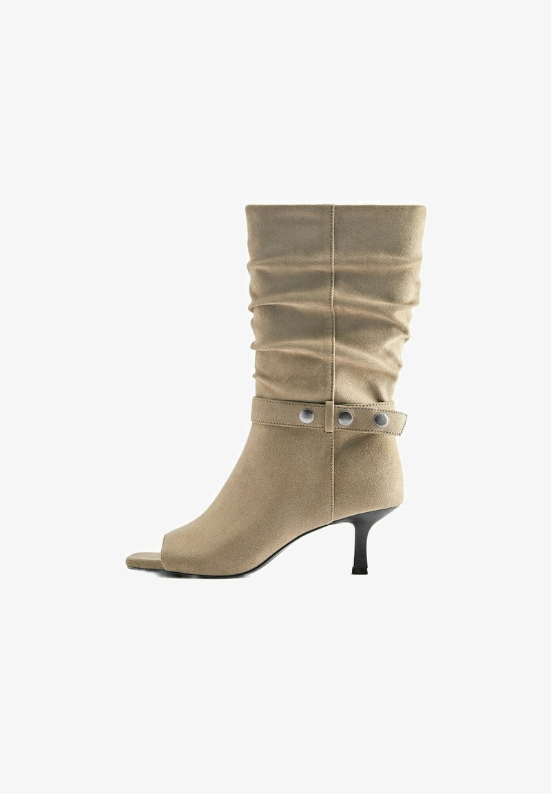 Botte beige en daim mi-mollet avec tige souple, bride décorative avec boutons argentés, bout ouvert et talon kitten noir fin.
