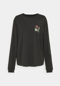 T-shirt nera a maniche lunghe con un design a taschino e una grafica tropicale colorata. Materiale morbido, colletto rotondo e vestibilità rilassata.