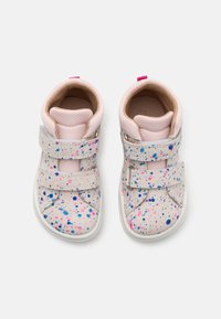 Rosa und weiße Sneakers mit einem gepunkteten Lackdesign in Blau und Rosa. Verfügt über Klettverschlüsse und einen gepolsterten Kragen für zusätzlichen Komfort.