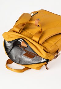 Zaino giallo con un'esterno liscio, spallacci imbottiti e un interno a quadri grigi, con un'etichetta in pelle e chiusura con zip.