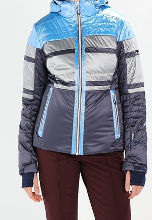 Veste matelassée avec blocs de couleur bleu, gris et marine, fermeture éclair frontale, poches zippées et trous pour le pouce aux manches longues.