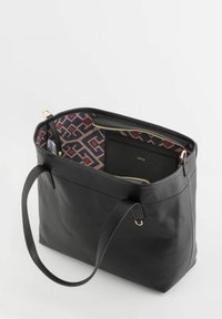 Sac fourre-tout en cuir noir avec une surface texturée, des ferrures dorées et un intérieur à motif. Comprend un compartiment principal et une petite poche zippée.