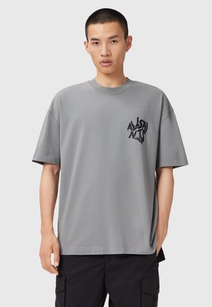 Grå bomulds t-shirt med korte ærmer, rund halsudskæring og et sort grafisk logo på venstre bryst. Casual pasform med en glat tekstur.