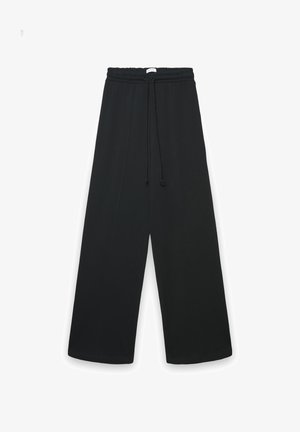 Pantaloni neri a gamba larga realizzati in tessuto morbido, con vita elastica dotata di coulisse e due cuciture verticali sul davanti.