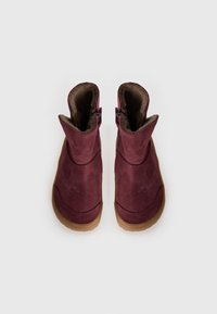 Bottines en daim bordeaux avec un intérieur doux, bout rond et deux fermetures éclair sur les côtés pour un enfilage facile. Semelles en caoutchouc.