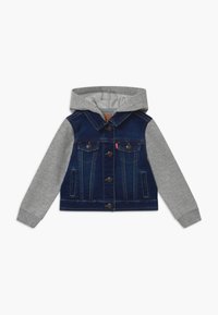 Giacca di jeans con maniche di felpa grigia, corpo blu scuro, bottoni frontali e due tasche sul petto. Fodera grigia chiara all'interno del cappuccio.