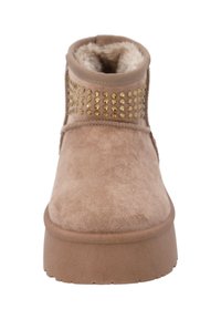 Beżowe botki za kostkę o zamszowym wykończeniu, z wyściółką wewnętrzną i dekoracyjnymi złotymi ćwiekami ułożonymi w rzędach. Posiadają grubą, teksturowaną podeszwę.
